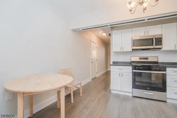 a kitchen with stainless steel appliances a stove a microwave and white cabinets