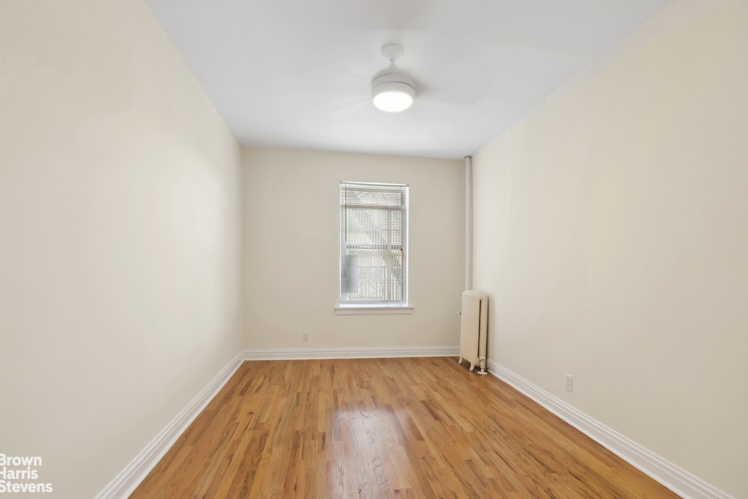 515 Edgecombe Avenue, Unit 41 Manhattan, NY 10032 - Photo 6 of 12 a view of an empty room with wooden floor and a window