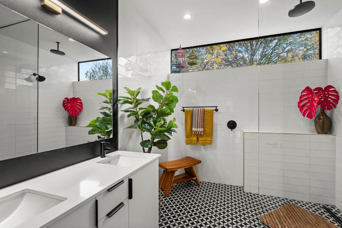 Beautiful spa shower is bright and airy with double vanities and custom tile and lighting.