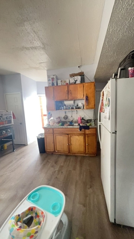 34 Beacon Street, Unit 1L Worcester, MA 01608 - Photo 3 of 9 a kitchen with stainless steel appliances granite countertop a refrigerator a sink and a stove