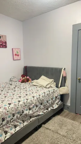 a bedroom with a bed and a wooden floor