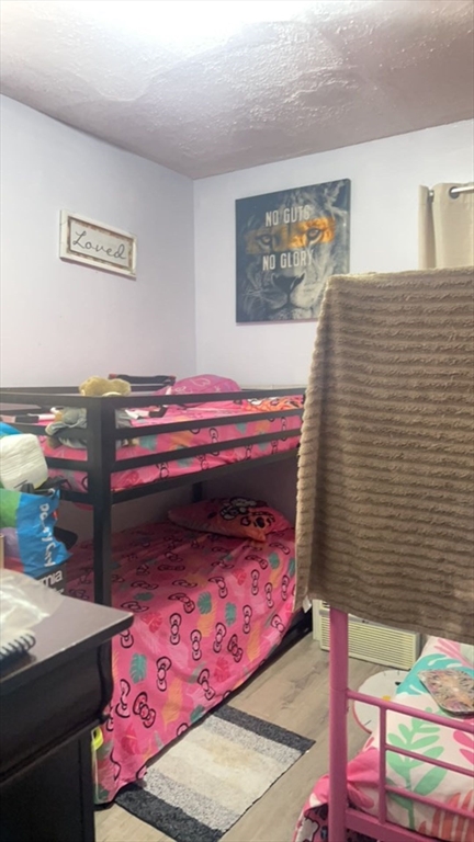 34 Beacon Street, Unit 1L Worcester, MA 01608 - Photo 8 of 9 a bedroom with a bed and a painting on the wall