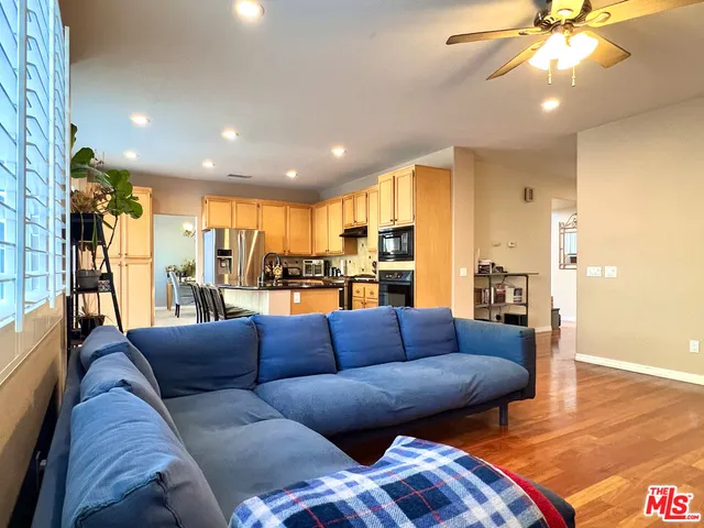 a kitchen with stainless steel appliances a refrigerator and wooden floor
