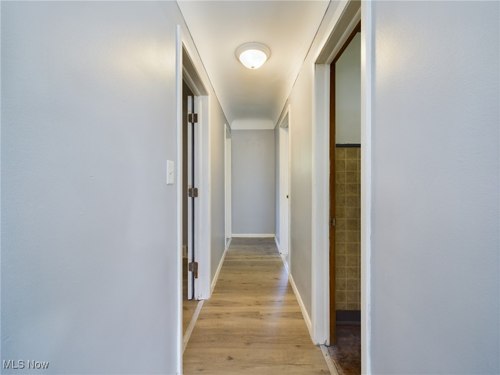 793 Alhambra Road Cleveland, OH 44110 - Photo 13 of 25 Corridor with tile walls and light hardwood / wood-style flooring