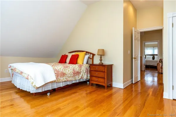 a bedroom with a bed and wooden floor