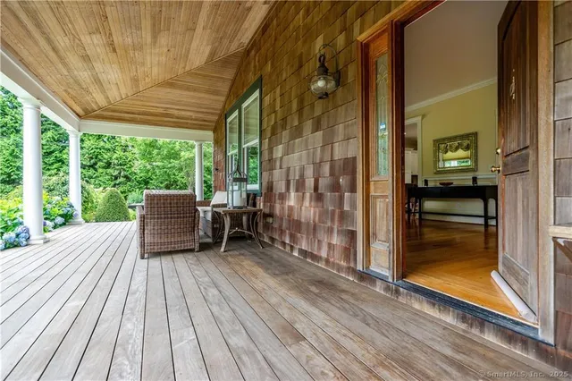 a view of a balcony with chairs and wooden floor