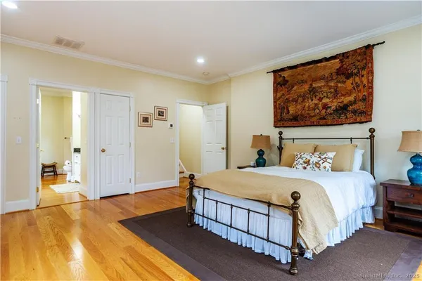 a bedroom with a bed and a painting on the wall