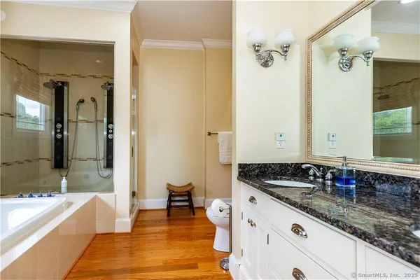 a spacious bathroom with a granite countertop tub sink and mirror