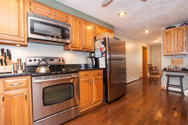 327 Sterling Road Holden, MA 01522 - Photo 6 of 30 a kitchen with stainless steel appliances granite countertop a refrigerator microwave and stove top oven