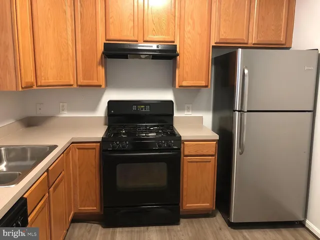 a kitchen with stainless steel appliances granite countertop a refrigerator and a stove
