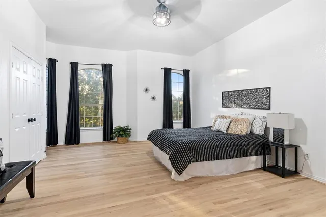 a bedroom with a large bed and a wooden floor