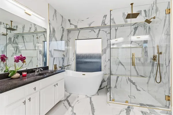 a bathroom with a granite countertop shower sink and cabinets