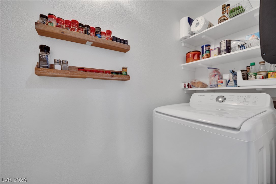 7570 West Flamingo Road, Unit 115 Las Vegas, NV 89147 - Photo 13 of 34 A well-organized utility area provides functional storage and a modern washer.