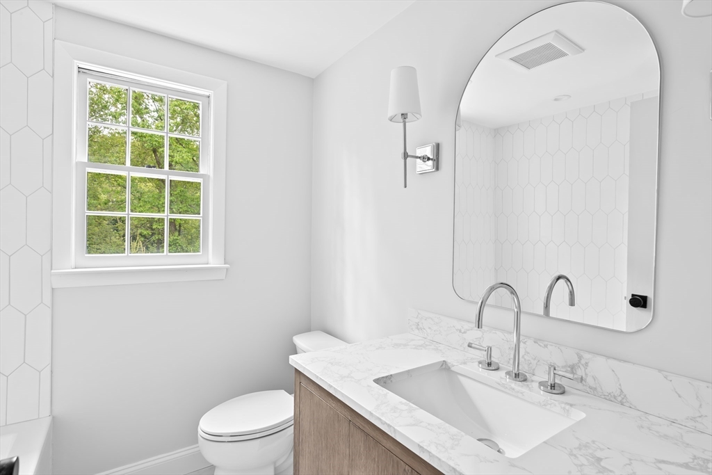 14 Spring Street Hingham, MA 02043 - Photo 21 of 28 a bathroom with a sink a toilet and a mirror