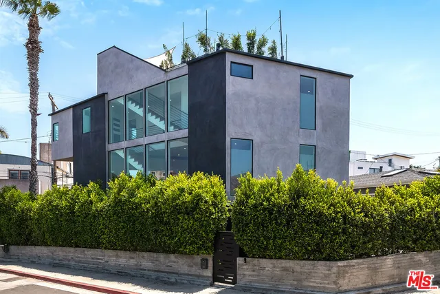a brick building with potted plants in front of it