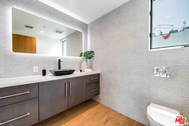 a spacious bathroom with a double vanity sink toilet and a mirror