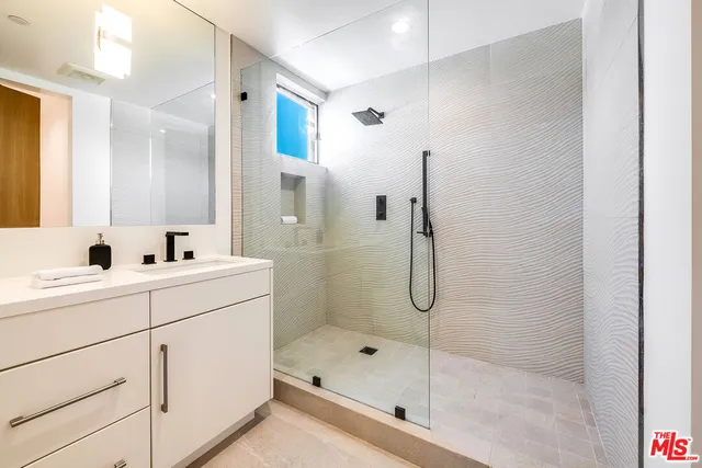 a bathroom with a shower sink and mirror