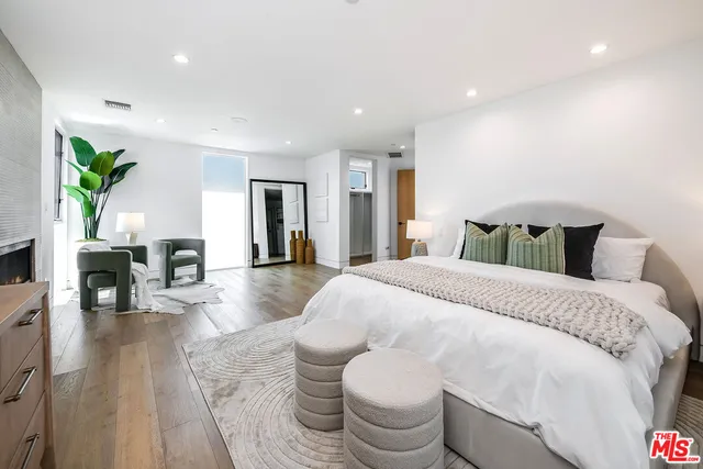 a spacious bedroom with a bed and wooden floor