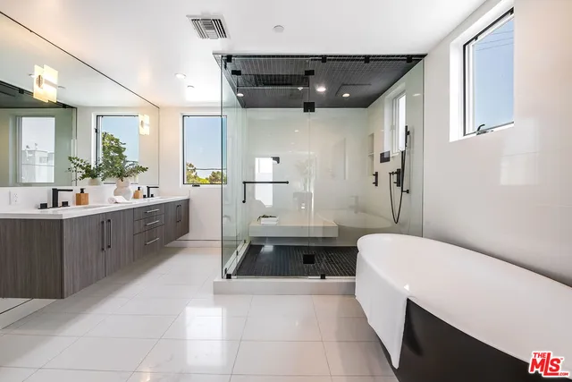 a spacious bathroom with a double vanity sink a mirror and a bathtub