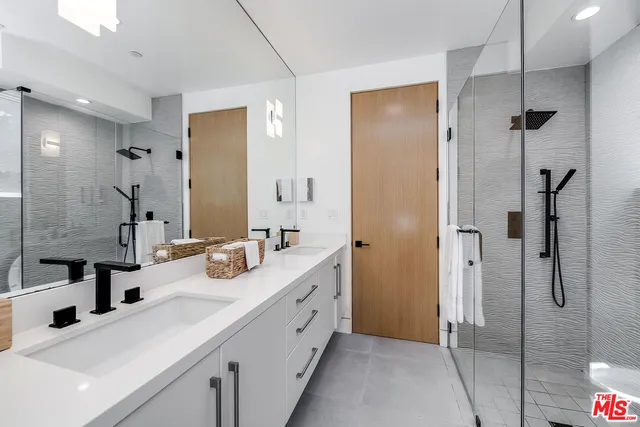 a bathroom with a double vanity sink mirror double and shower