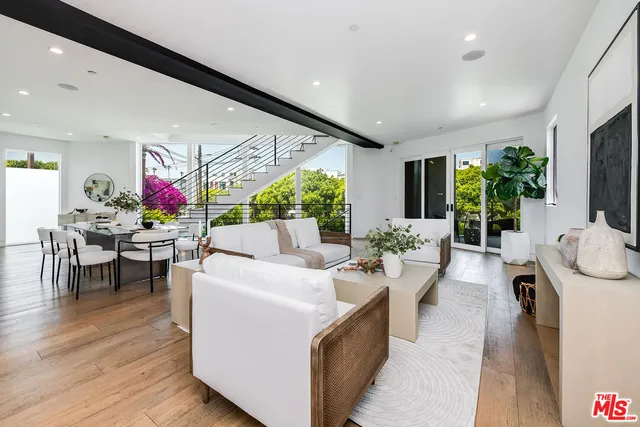 a living room with furniture a flat screen tv and a floor to ceiling window