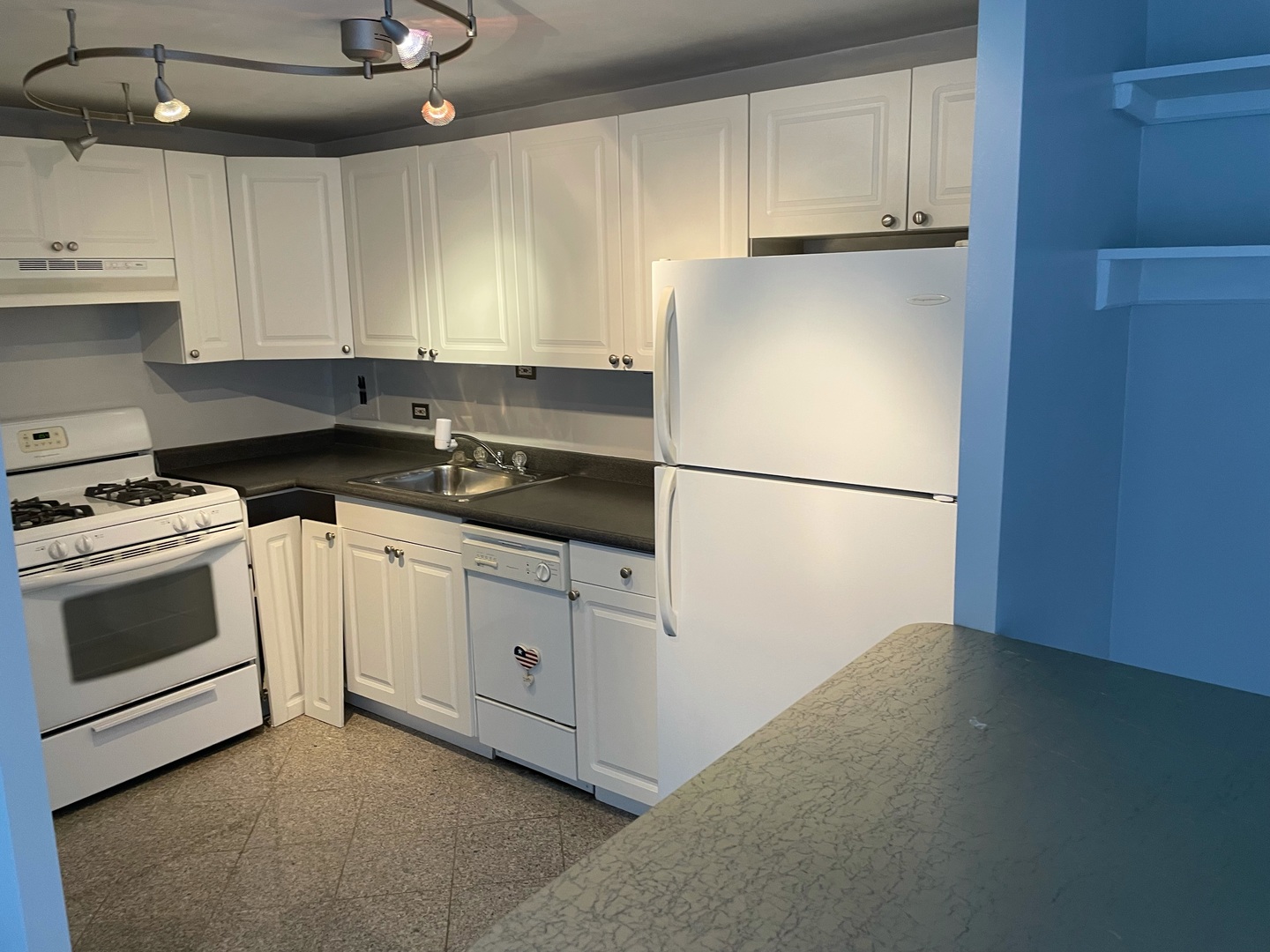 253 East Delaware Place, Unit 16E Chicago, IL 60611 - Photo 4 of 13 a kitchen with white cabinets and white appliances