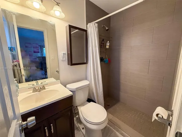 a bathroom with a sink a toilet a shower and a mirror