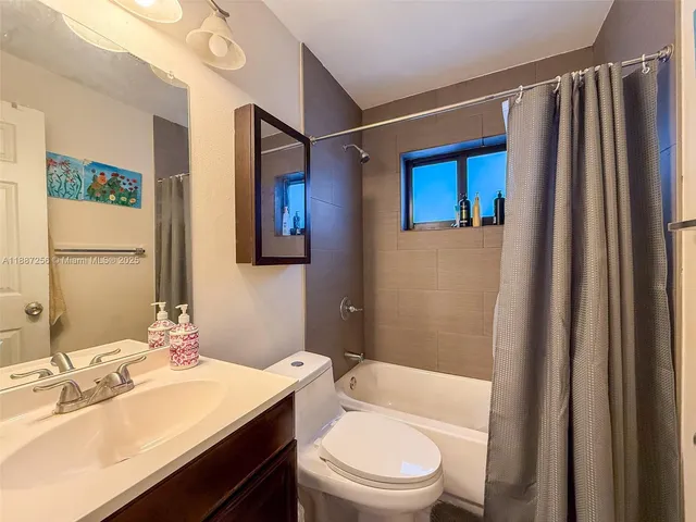 a bathroom with a sink a toilet a mirror and shower