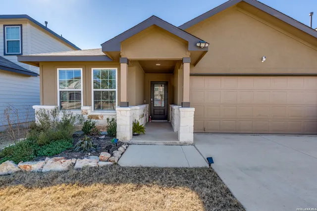 a view of a house with potted plants in front of door