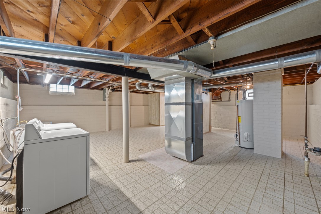 3261 Berea Road Cleveland, OH 44111 - Photo 29 of 43 Spacious basement with exposed wood joists, tile flooring, and white brick accents
