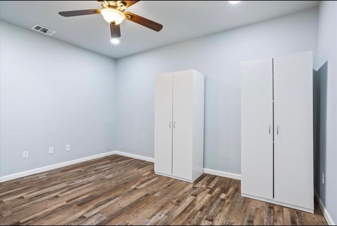 117 Emma Street, Unit B Bartlett, TX 76511 - Photo 11 of 18 an empty room with a ceiling fan and wooden floor