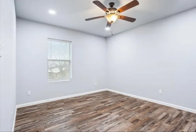 an empty room with a window and a fan