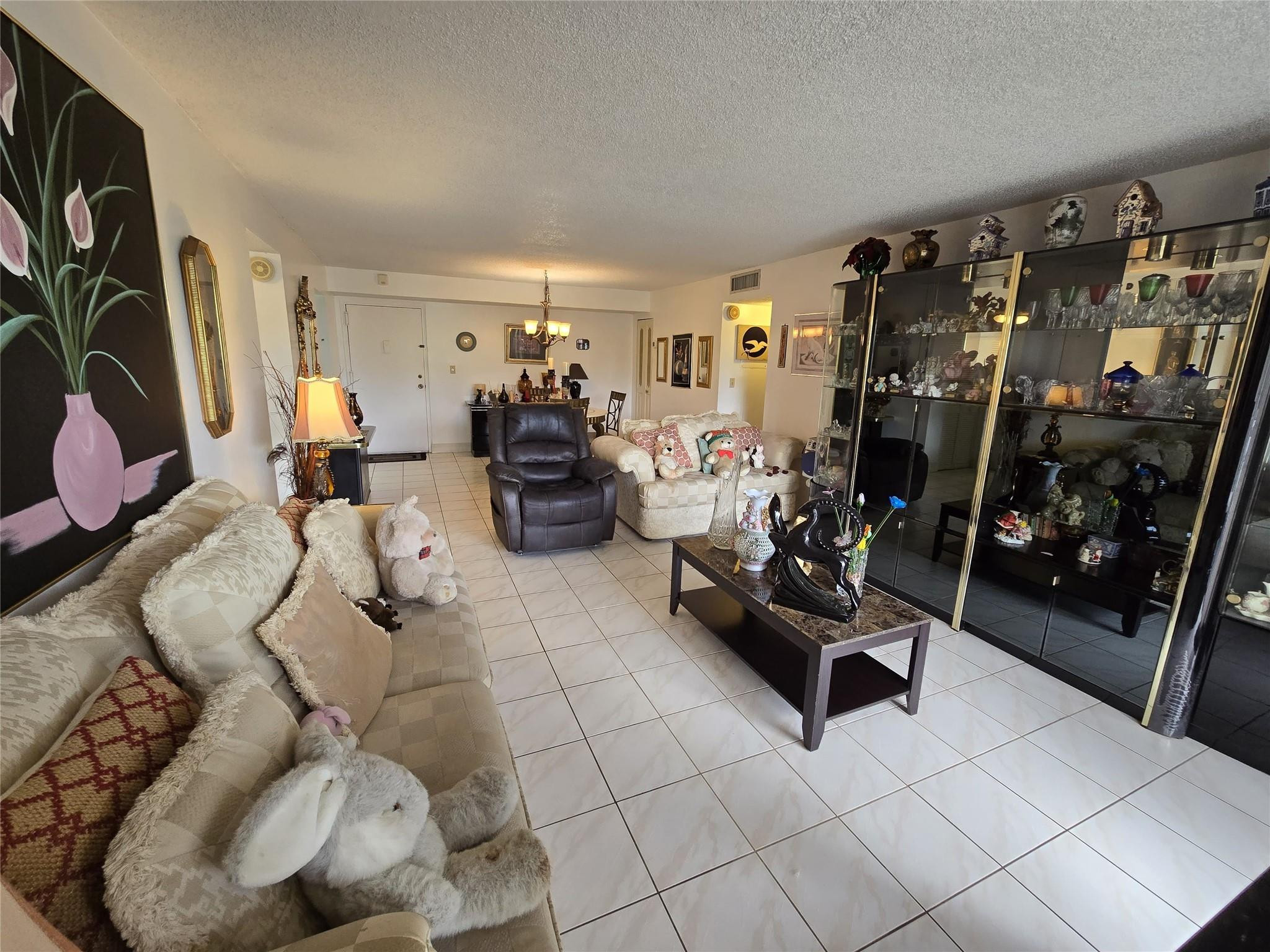 6195 Rock Island Road, Unit 215 Tamarac, FL 33319 - Photo 17 of 37 a living room with furniture and a flat screen tv