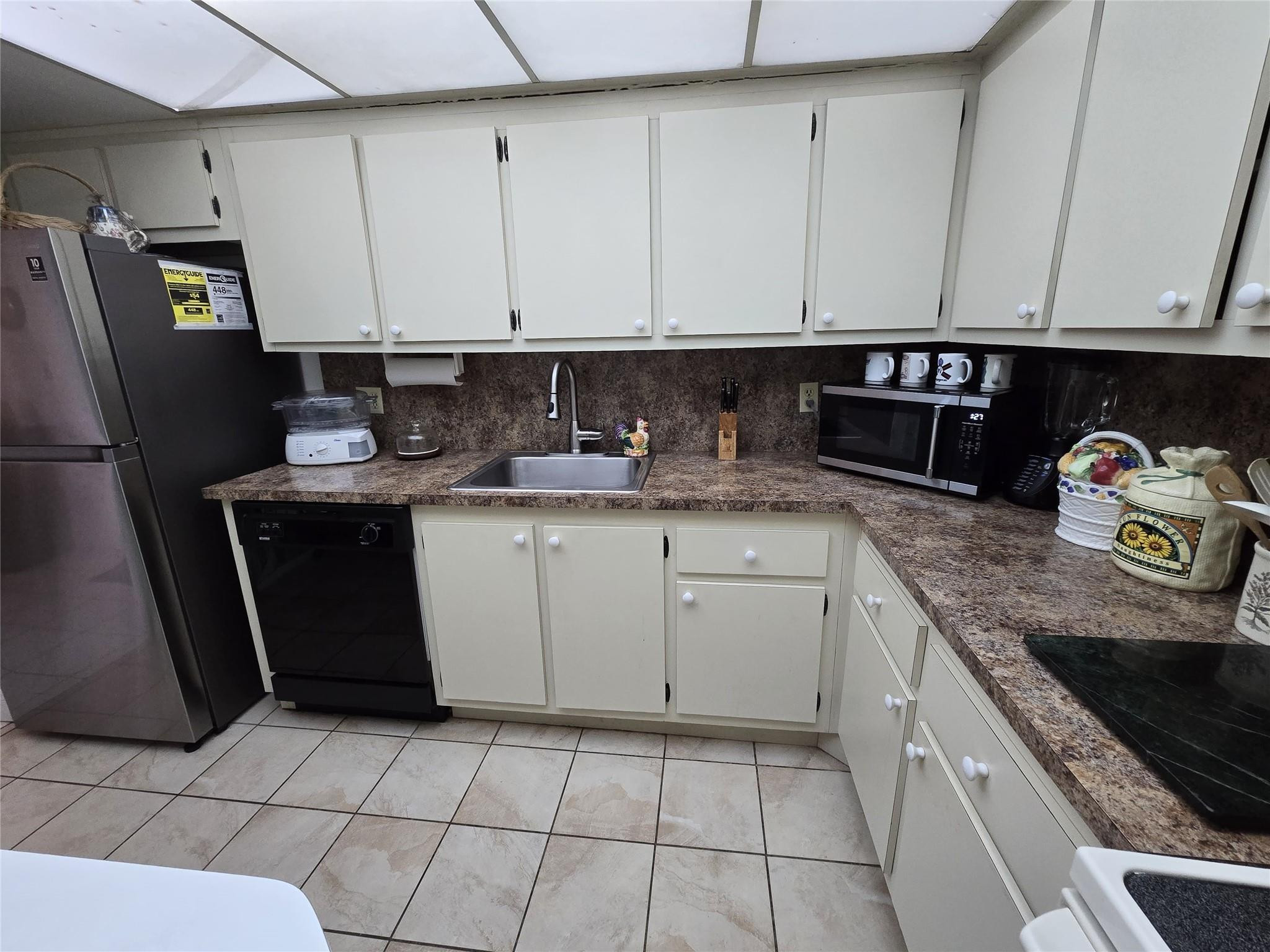 6195 Rock Island Road, Unit 215 Tamarac, FL 33319 - Photo 21 of 37 a kitchen with stainless steel appliances granite countertop a sink stove and refrigerator