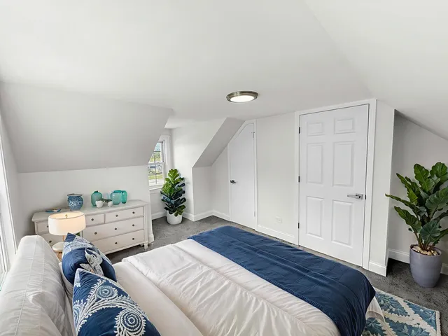 a bedroom with a bed and a potted plant