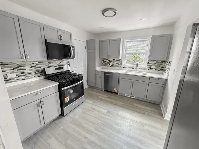 a kitchen with stainless steel appliances a stove sink and microwave