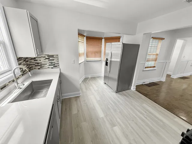 a kitchen with wooden floors and appliances