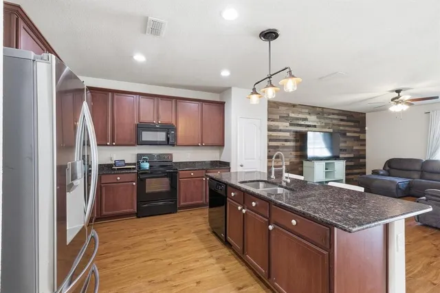 a kitchen with stainless steel appliances granite countertop a sink stove and refrigerator