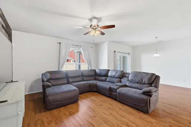 a living room with furniture and a ceiling fan