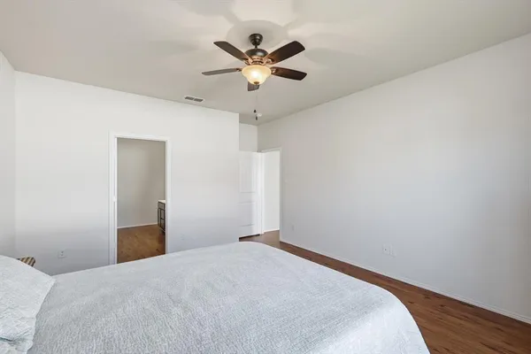 a bedroom with a bed and a ceiling fan