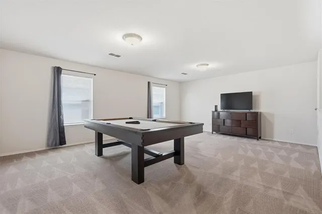 a room with furniture pool table and flat screen