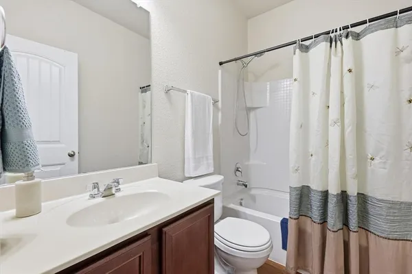 a bathroom with a sink a toilet a mirror a vanity and shower