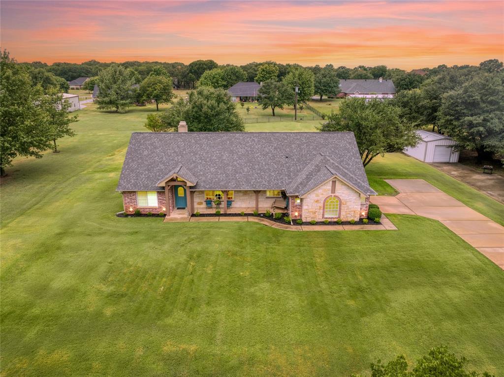 an aerial view of a house with pool big yard and large trees