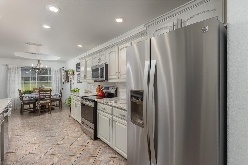 510 Highland Road Springtown, TX 76082 - Photo 16 of 40 a kitchen with stainless steel appliances granite countertop a refrigerator and a stove top oven