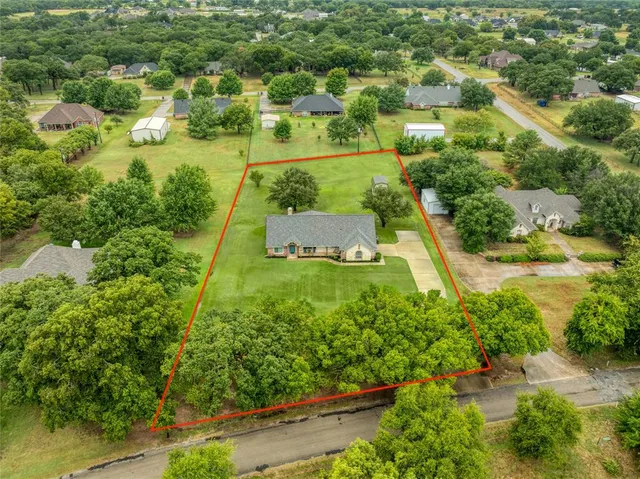 an aerial view of residential houses with outdoor space and trees all around