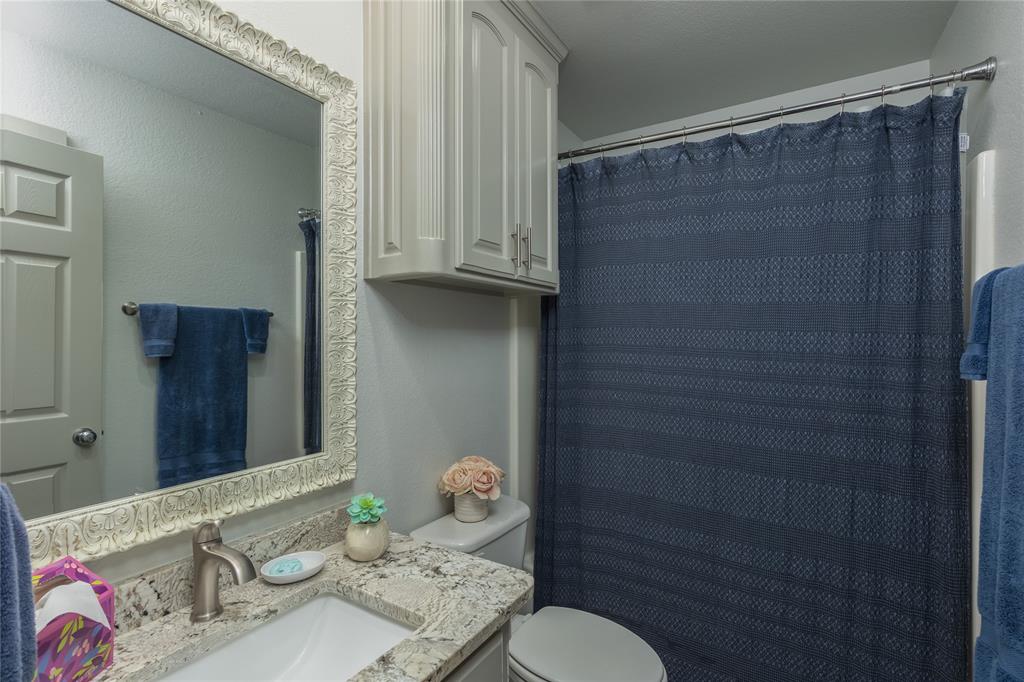 510 Highland Road Springtown, TX 76082 - Photo 23 of 40 a bathroom with a sink a toilet and shower curtain