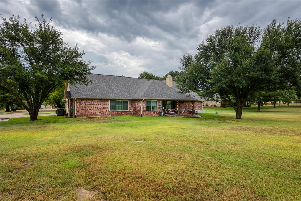 510 Highland Road Springtown, TX 76082 - Photo 32 of 40 a view of a big house with a big yard and large trees
