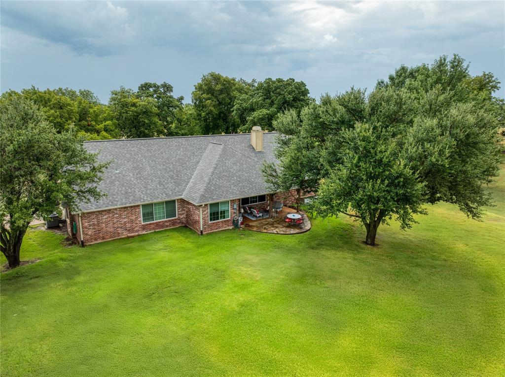 510 Highland Road Springtown, TX 76082 - Photo 6 of 40 a view of a patio with table and chairs and wooden fence