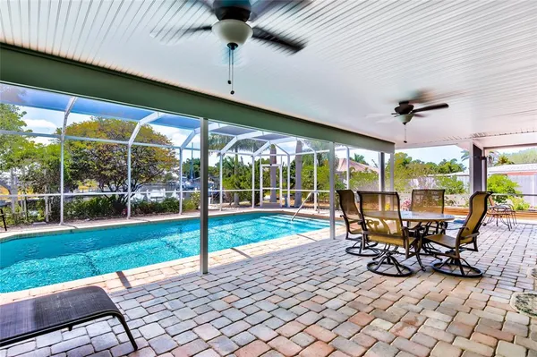 a view of a patio with table and chairs potted plants with floor to ceiling window