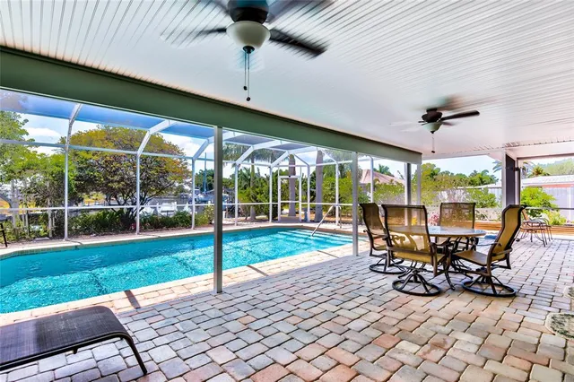 a view of a patio with table and chairs potted plants with floor to ceiling window